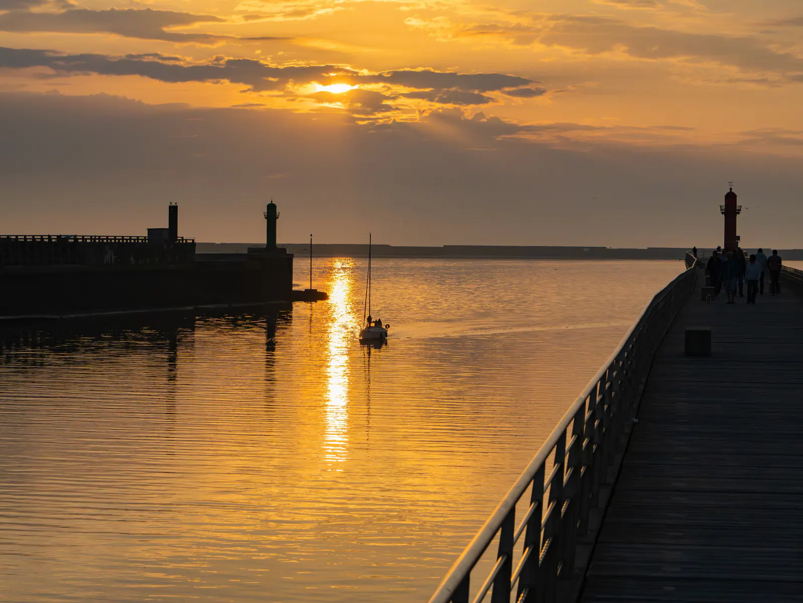 Coucher de soleil doré sur le port avec phares et bateaux amarrés, Côte d'Opale