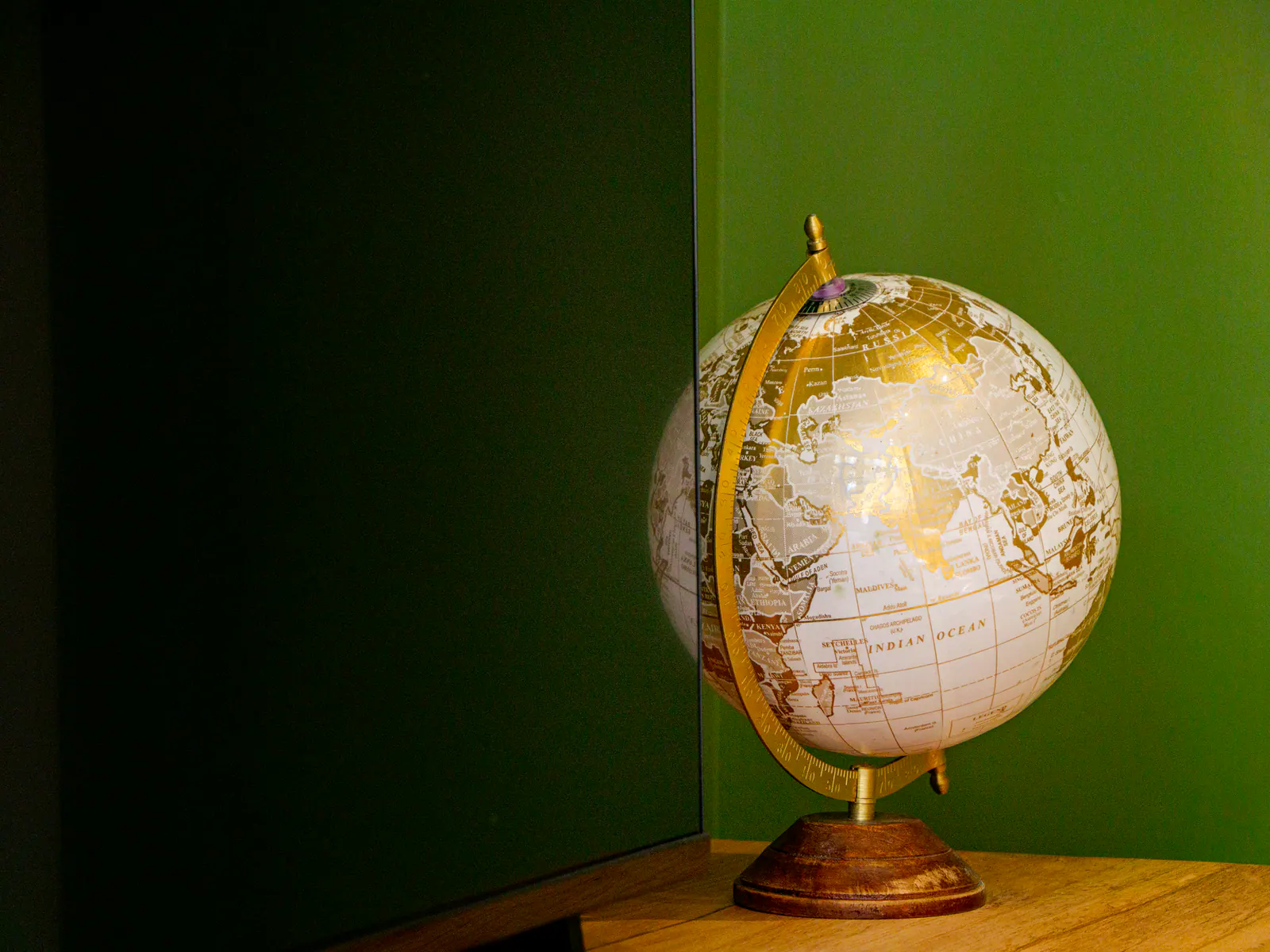 Globe terrestre vintage blanc et doré posé sur socle bois, décoration intérieure élégante